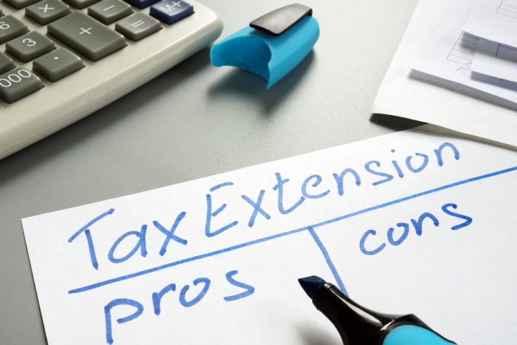 Tax extension pros and cons list on desk.